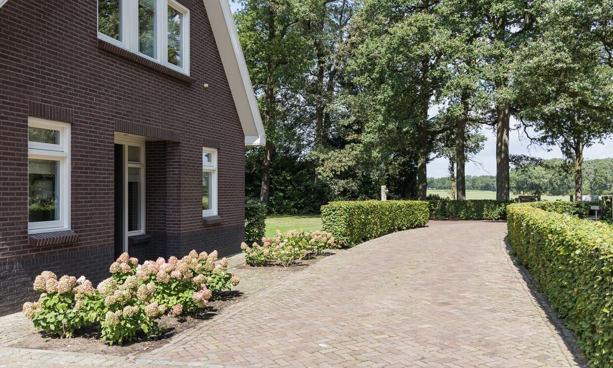 De gevel met knipvoeg langs de oprit van gebakken klinkers