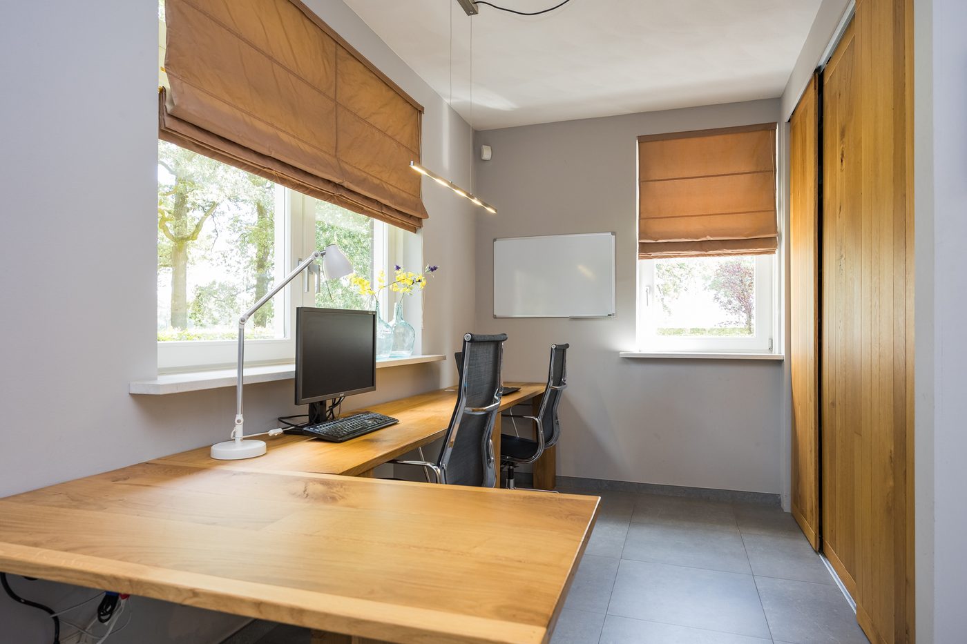De kantoorruimte in het woonhuis, met bureau en vaste schuifkast