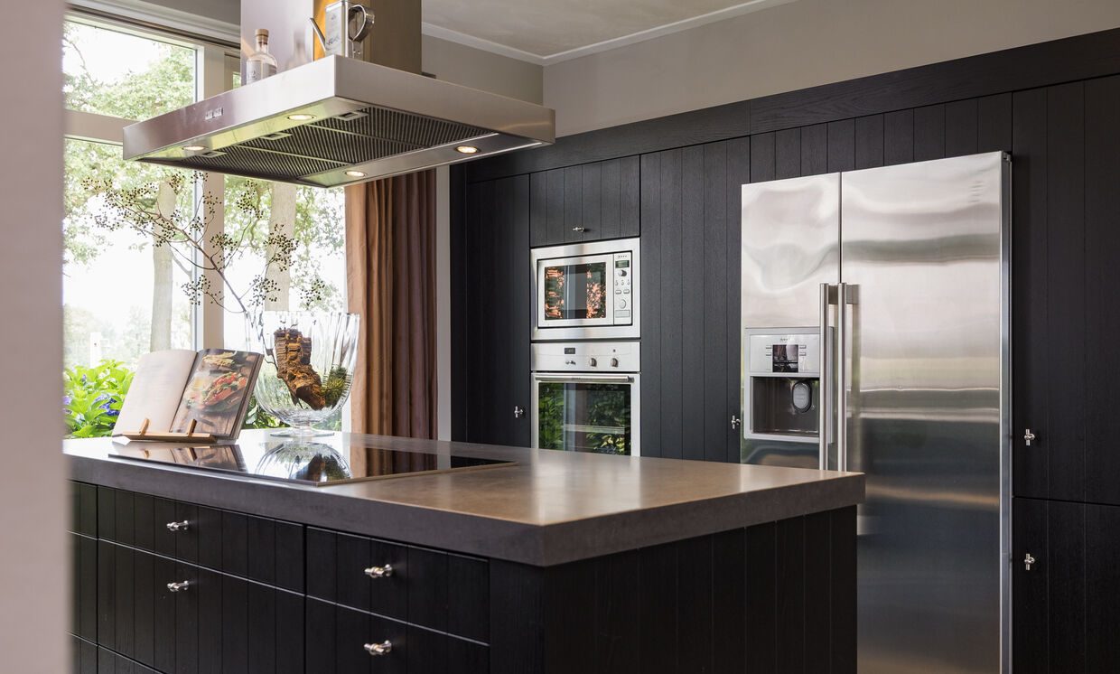 De kastenwand met combi-oven, magnetron en Amerikaanse koel-vriescombinatie