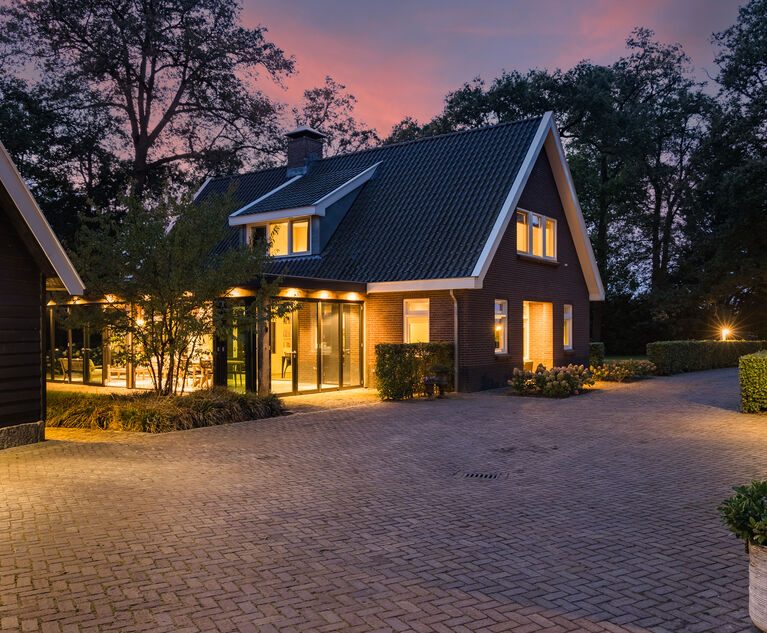Het landhuis bij schemering, gezien vanaf de verlichte oprit