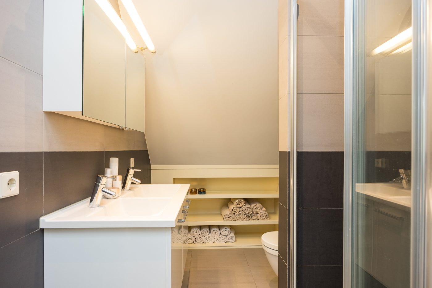 De eigen badkamer bij de ouderslaapkamer, met dubbele wastafel, inloopdouche en toilet