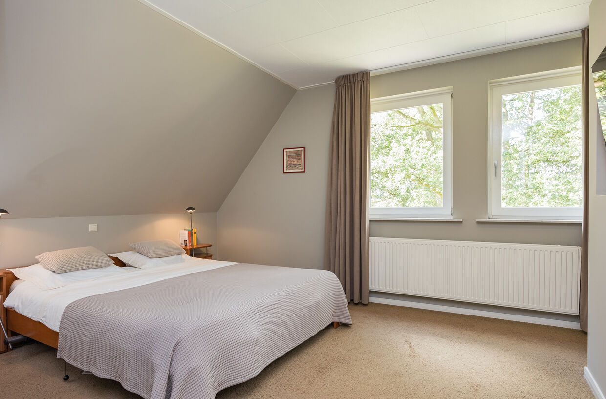 Doorkijk door openstaande deuren naar een slaapkamer